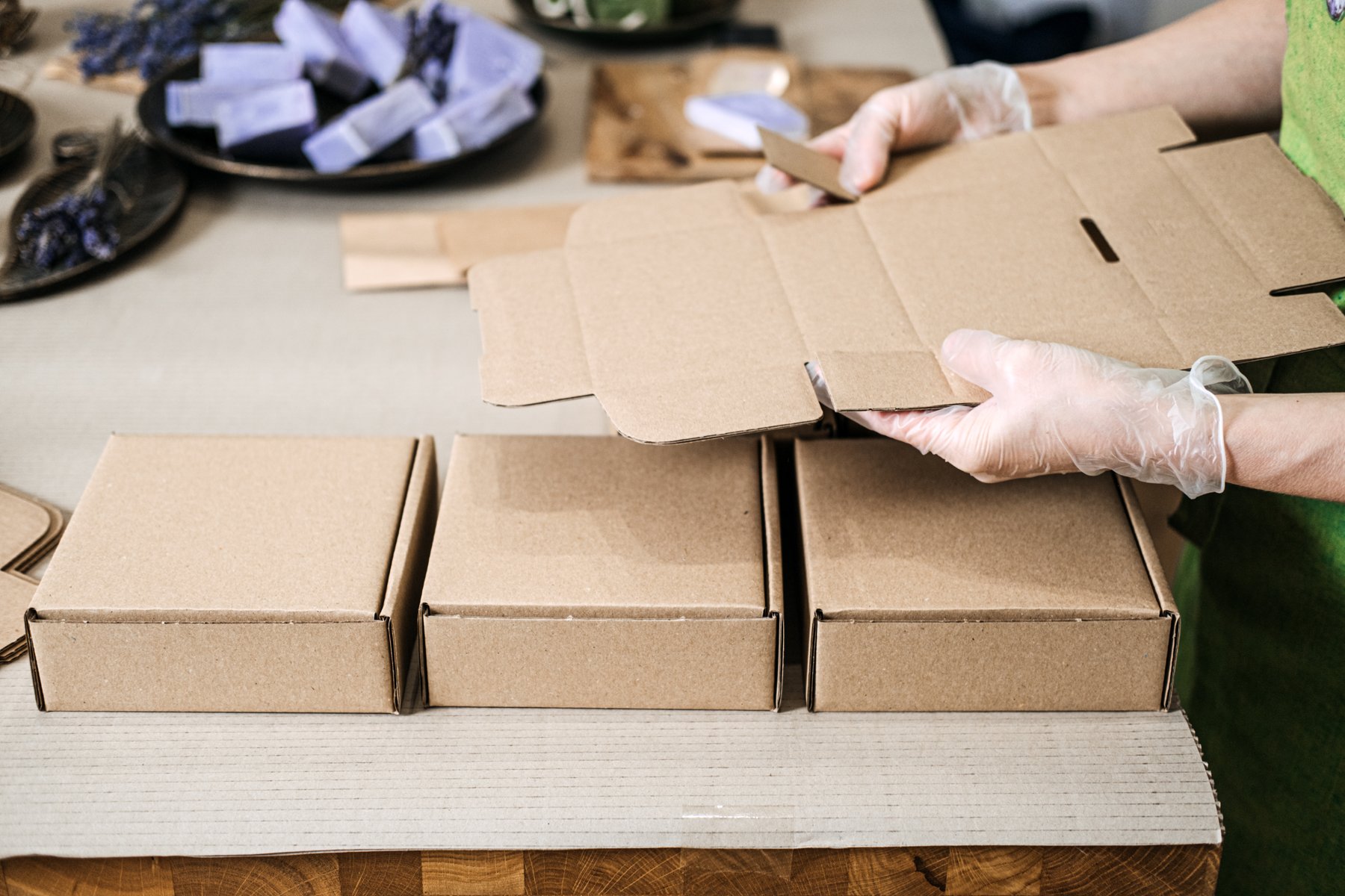 Hands preparing product packaging at a table