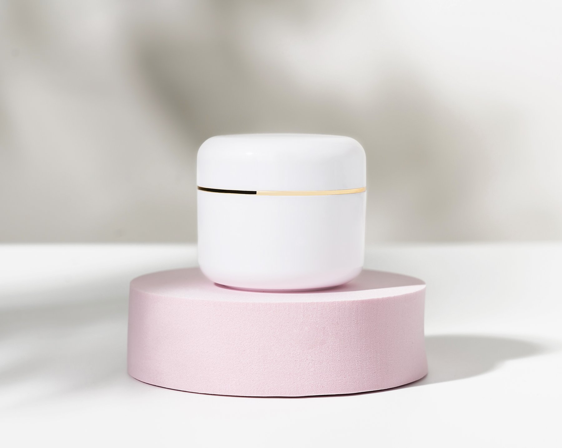 Clean cosmetic product view on a pink pedestal