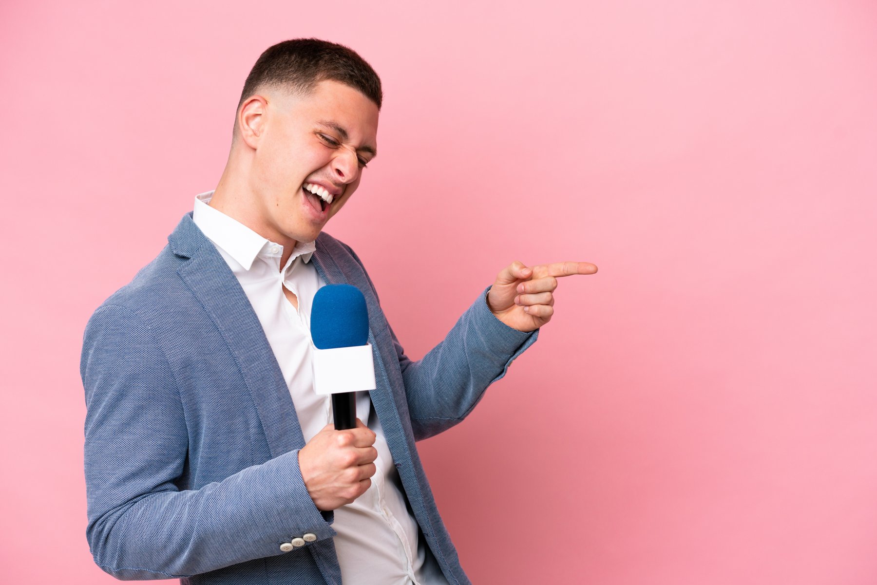 Presenter using a microphone against a pink background
