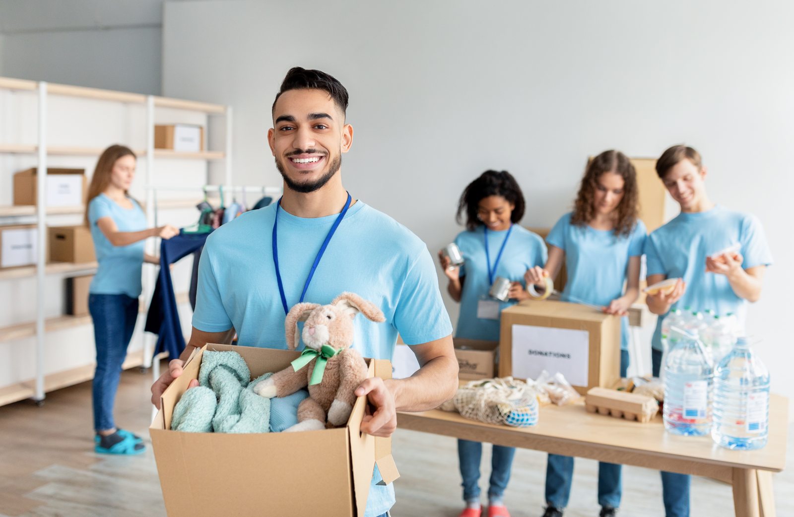Volunteer holding a box of donated clothing and toys