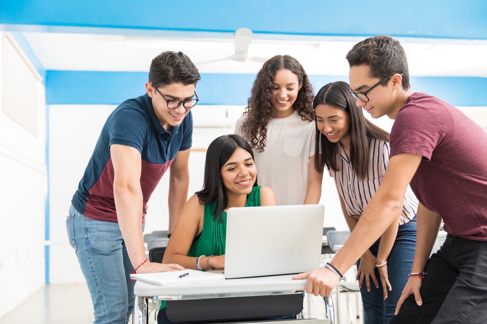 Students collaborating around a laptop