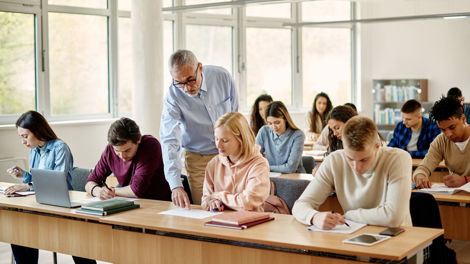 Professor supporting students in a classroom