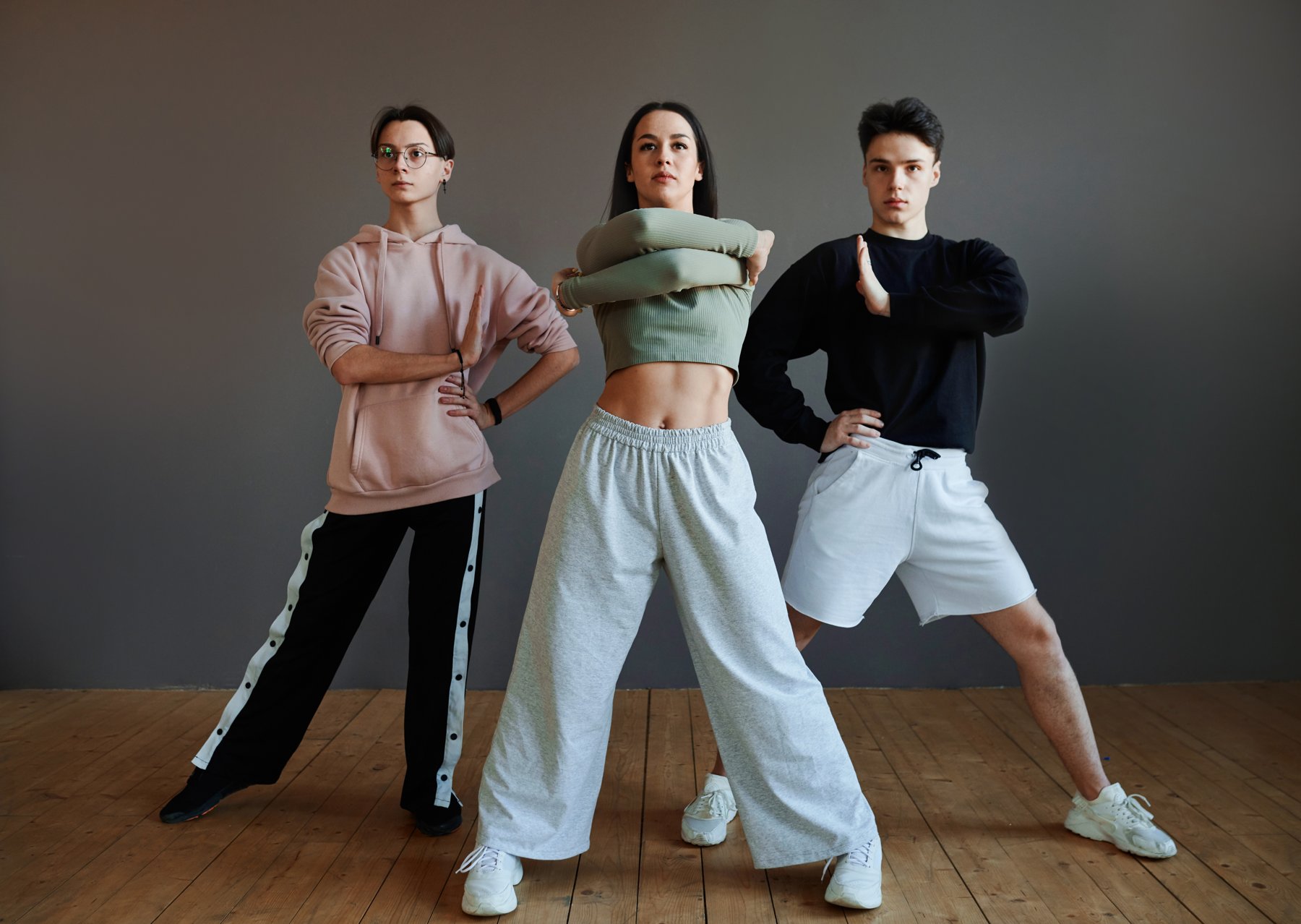 Three dancers performing coordinated group choreography