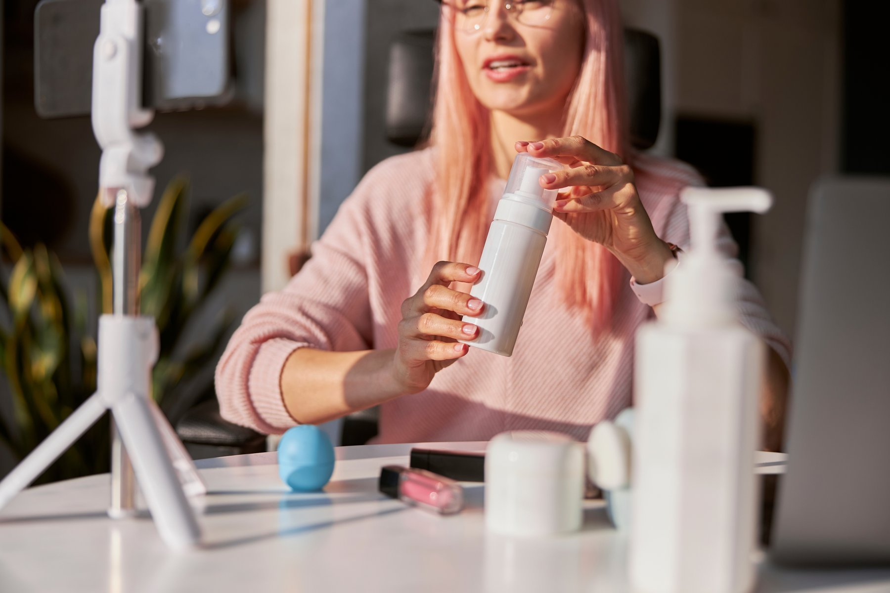 A beauty presenter demonstrating a cosmetic product to camera