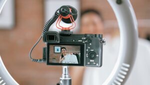 A camera recording a clothing presenter through a ring light