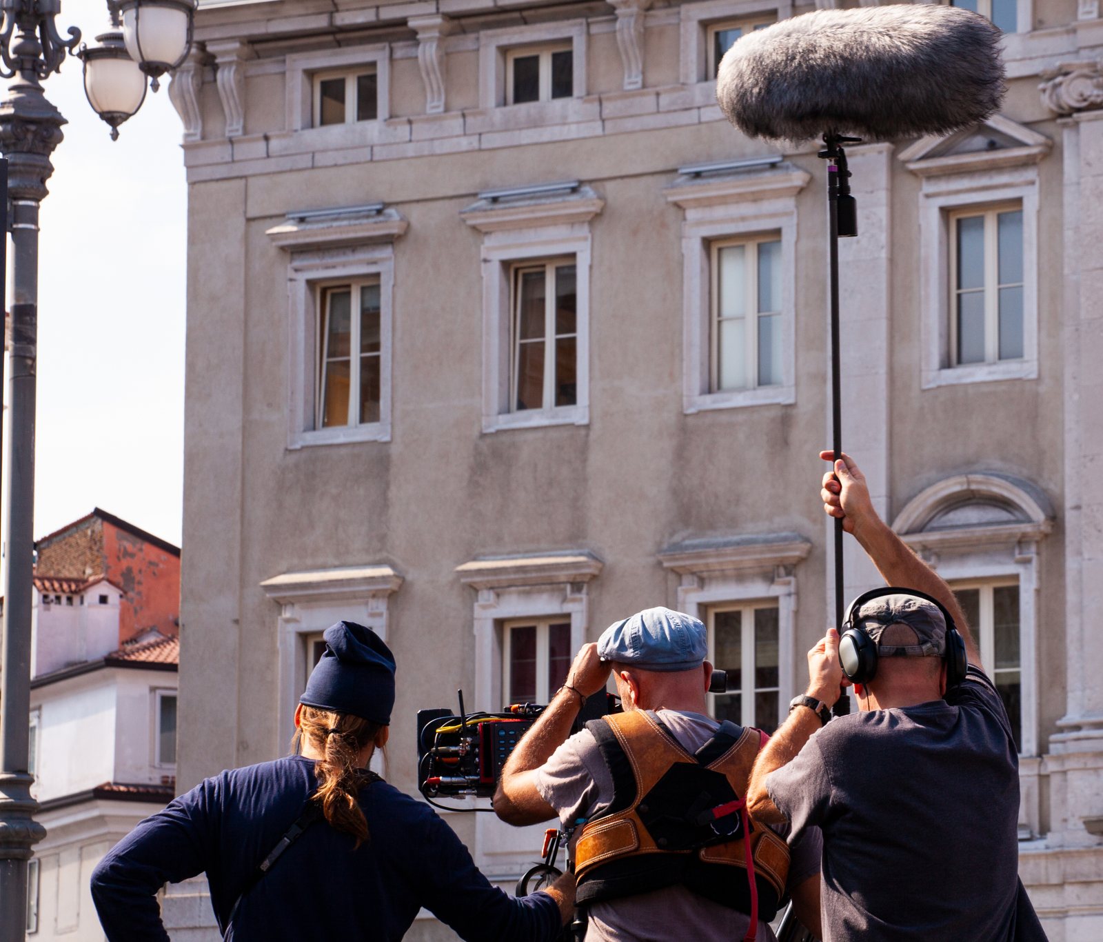 Film crew with camera and boom microphone on location