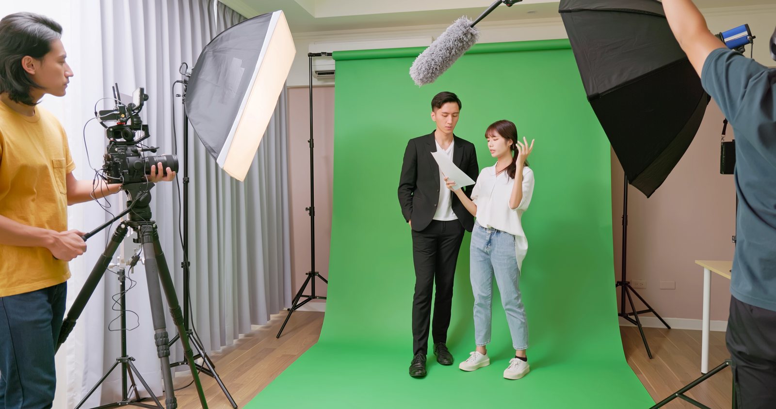 Film crew preparing performers for a green-screen scene