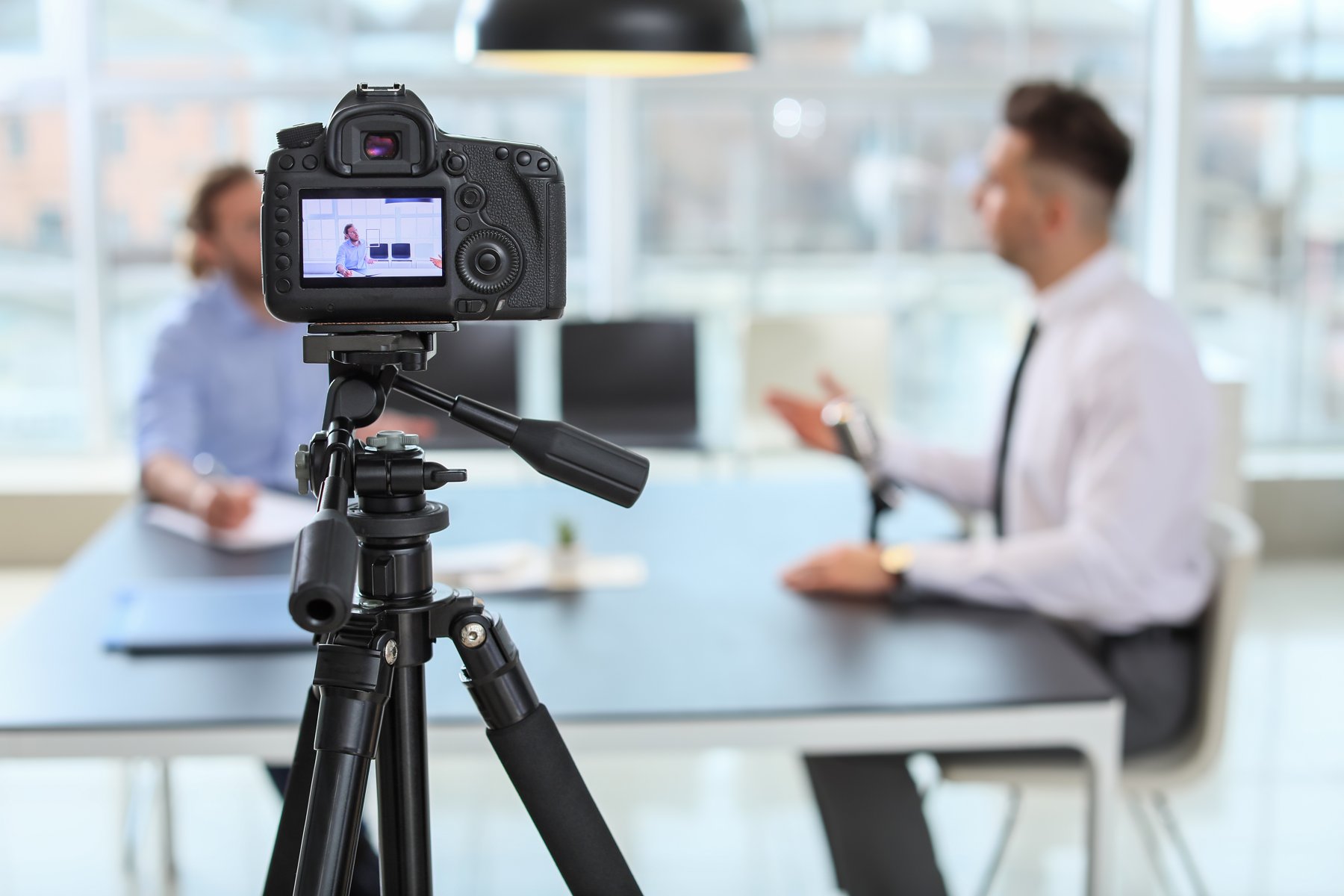 Camera recording two business people in an office interview