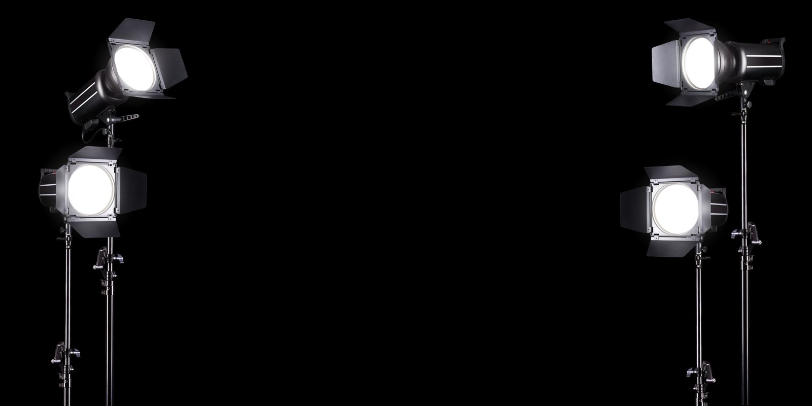 Studio lighting heads on stands against a black background
