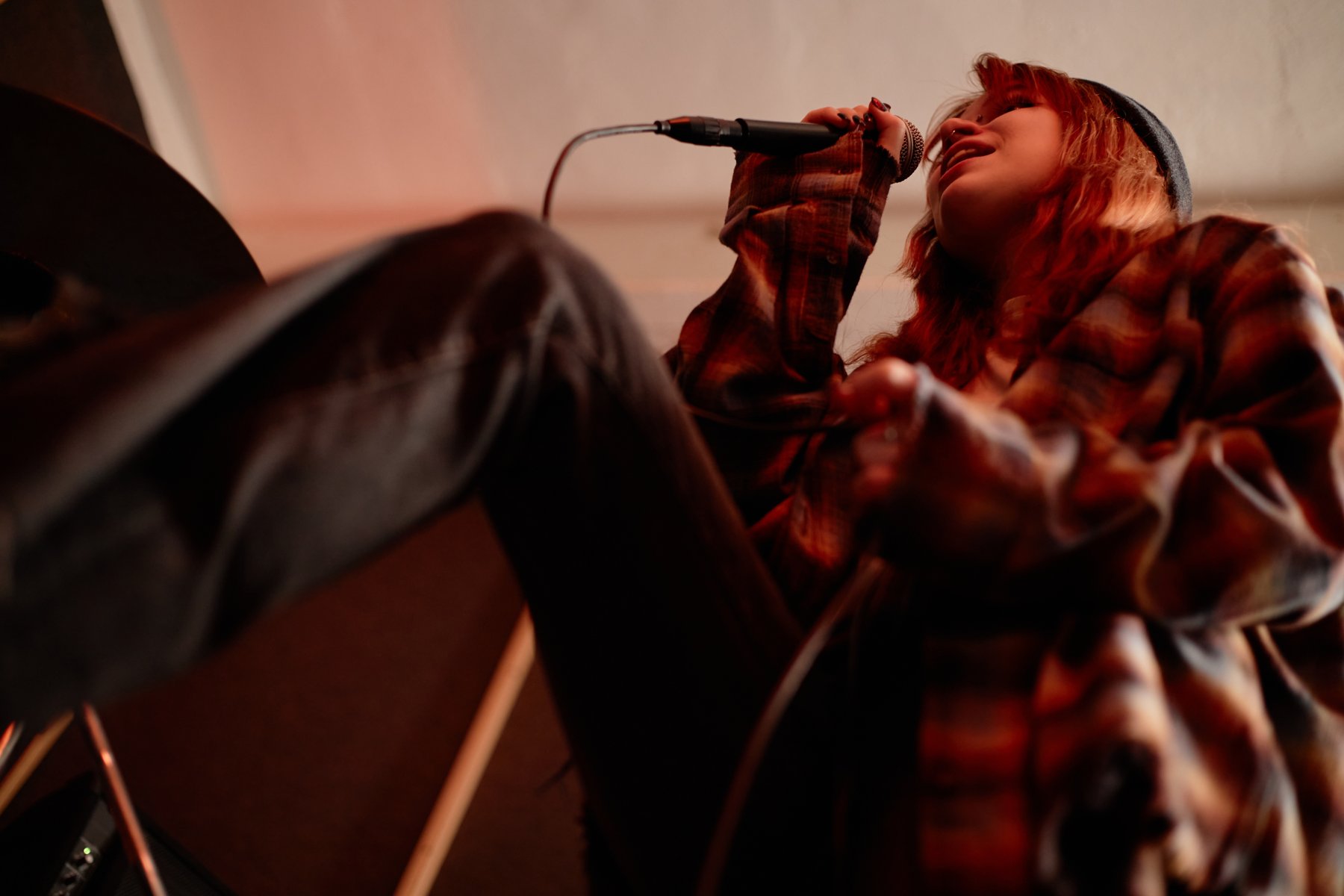 Singer performing into a microphone during a band session