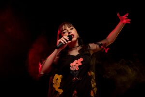 Singer holding a microphone in dramatic red light