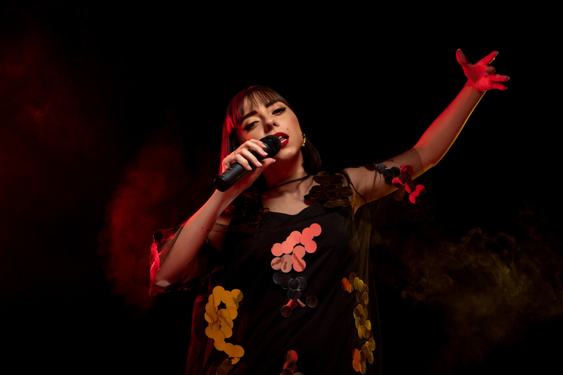 Singer holding a microphone in dramatic red light