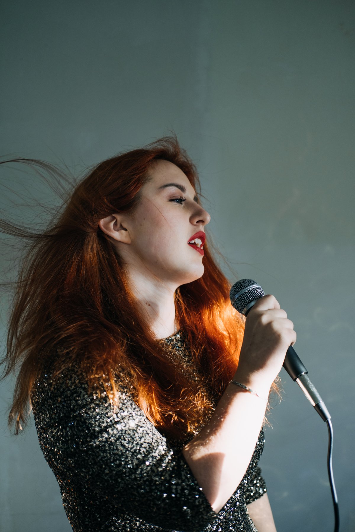 Singer in a sequinned outfit holding a microphone