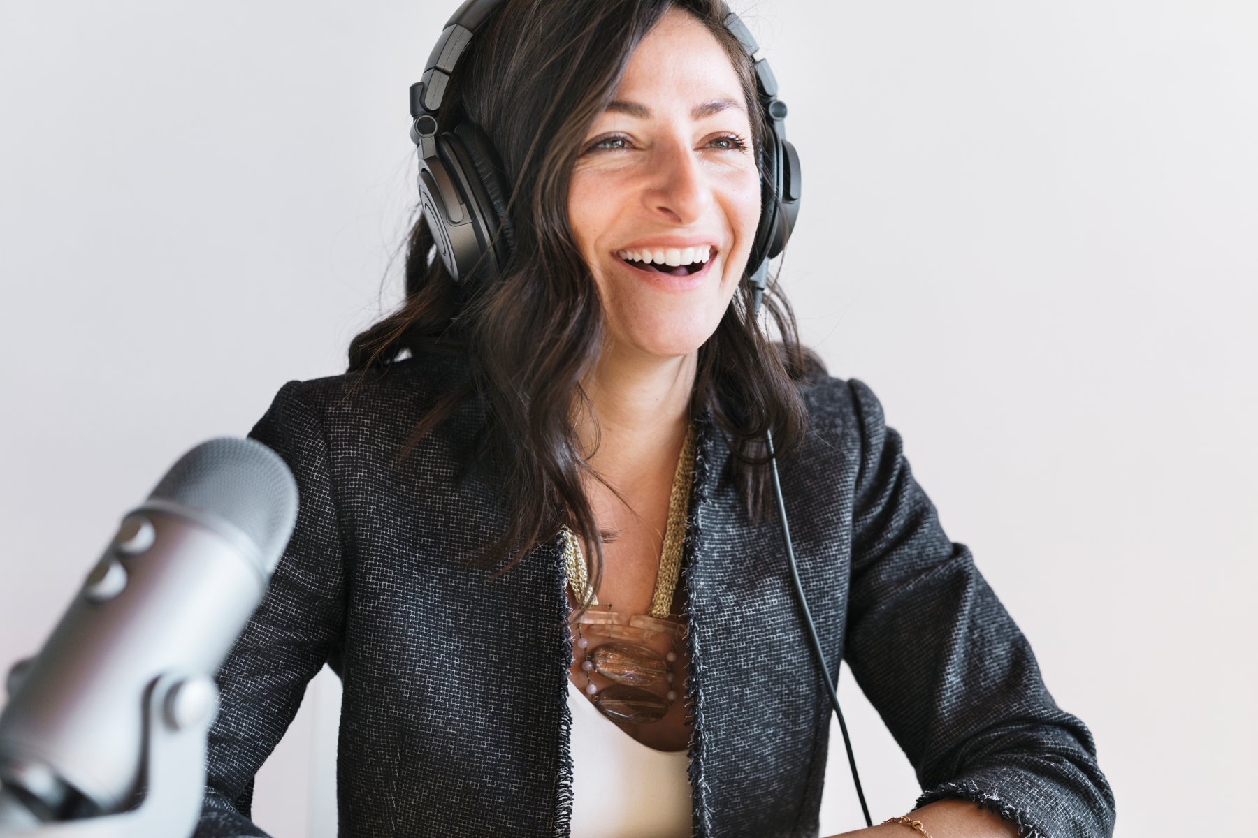 A smiling podcast guest speaking into a microphone