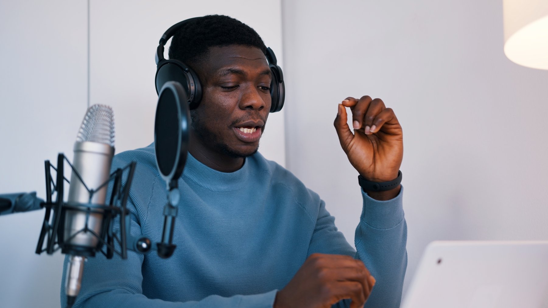 A podcast presenter wearing headphones and speaking into a microphone