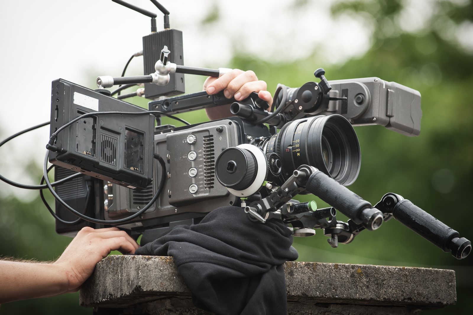 Close-up of a cinema camera being prepared by a crew member