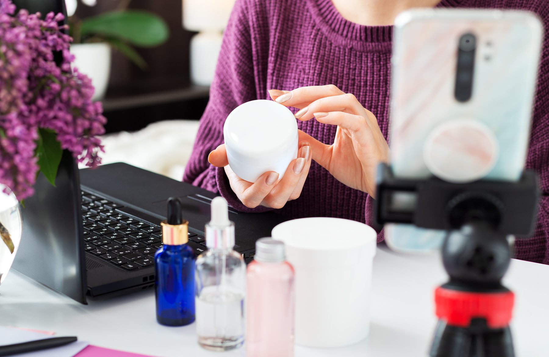 Hands demonstrating a cream product for a camera