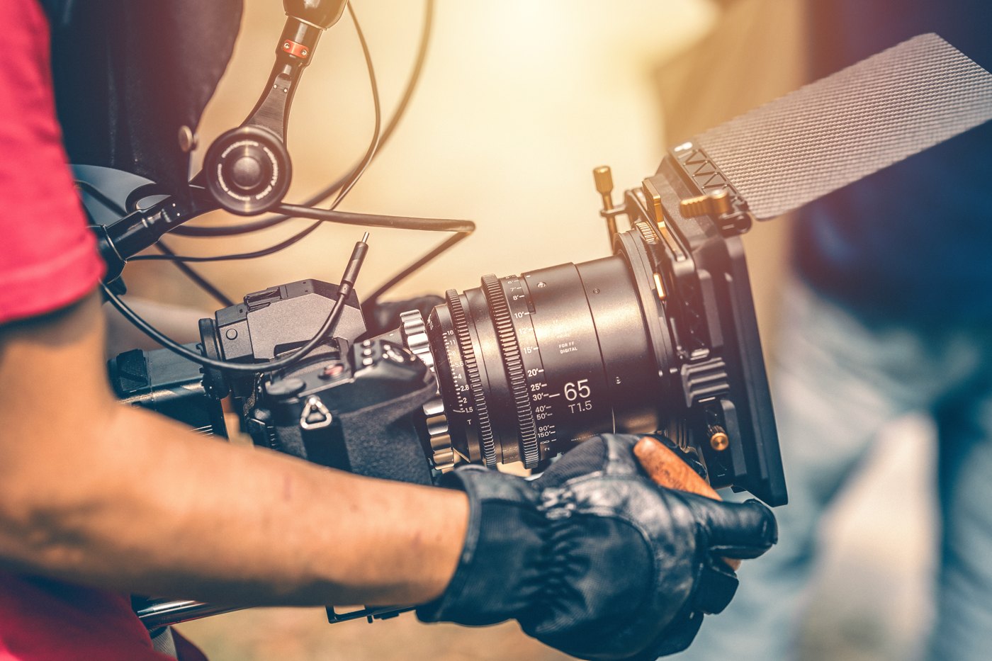 Camera operator adjusting a cinema camera during a production