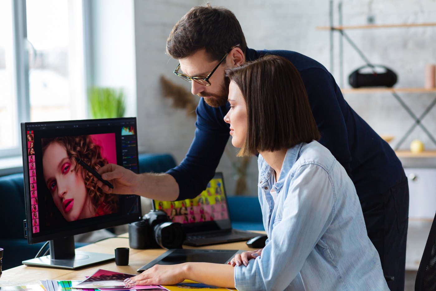 Creative team reviewing a portrait and colour references at a workstation