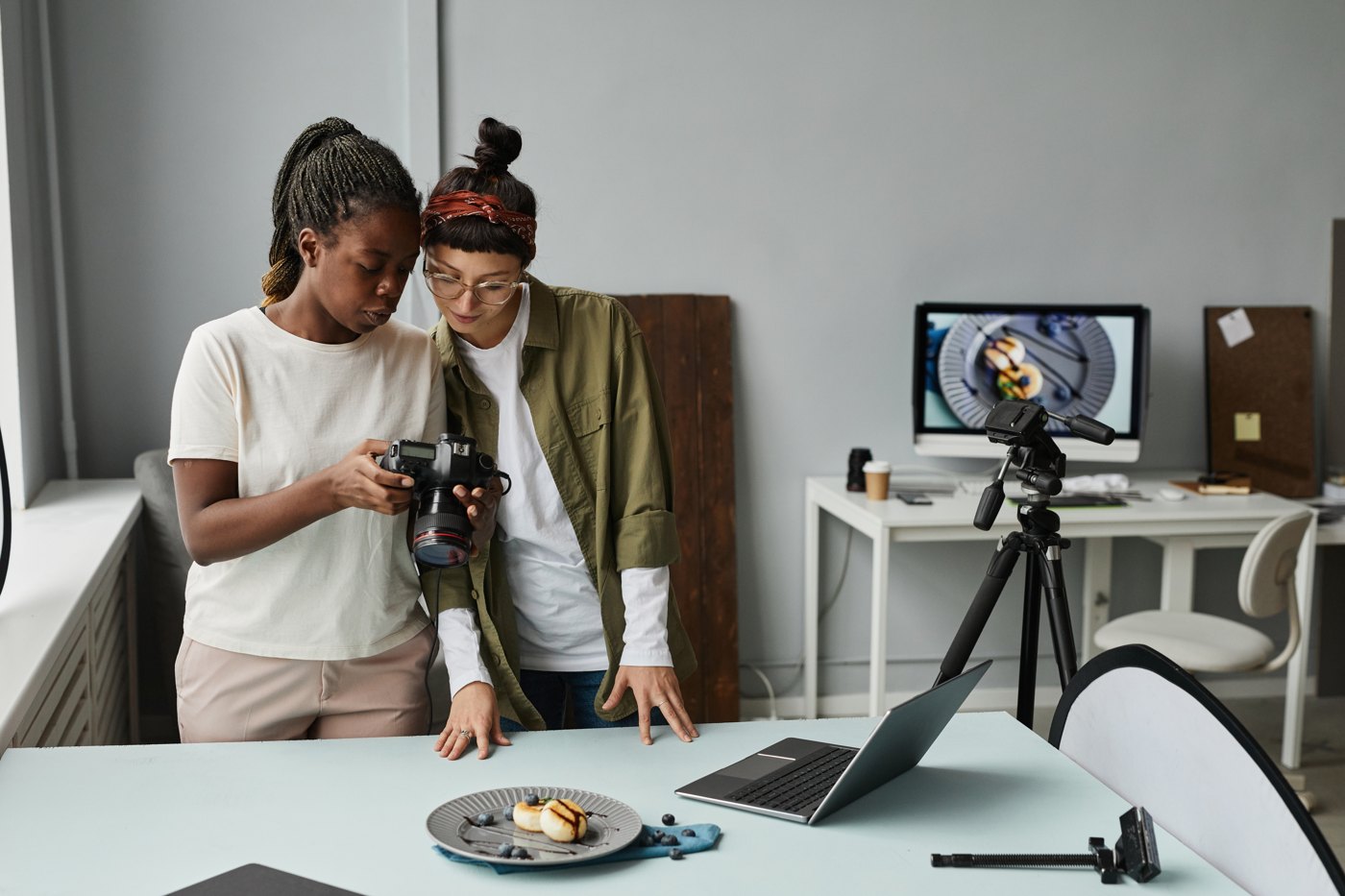 Photographers checking a camera beside a tabletop product setup