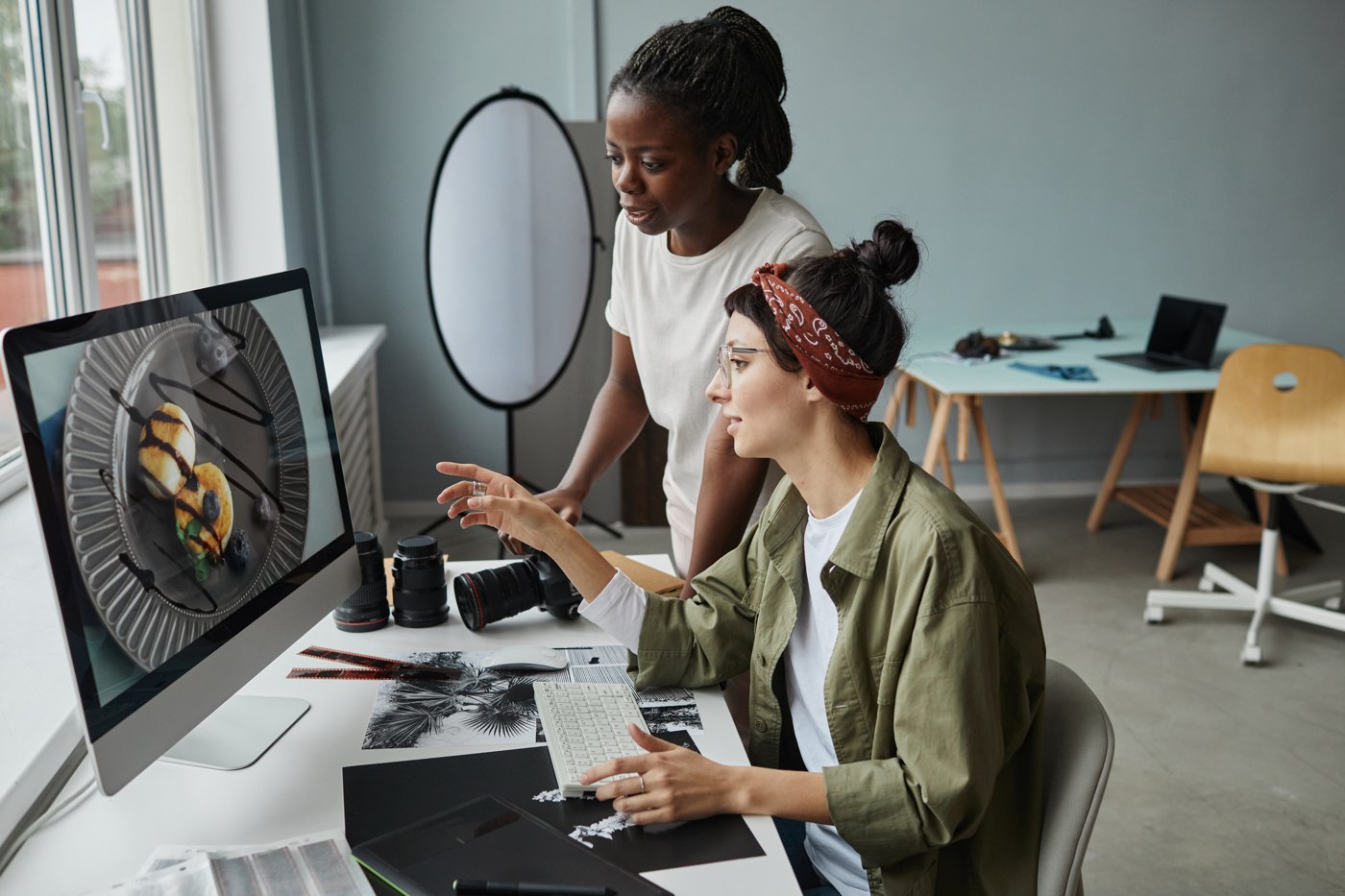 Two photographers comparing images on a computer screen