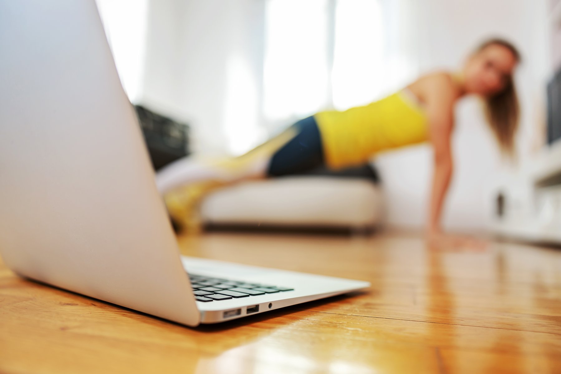 An instructor demonstrating a workout beside a laptop