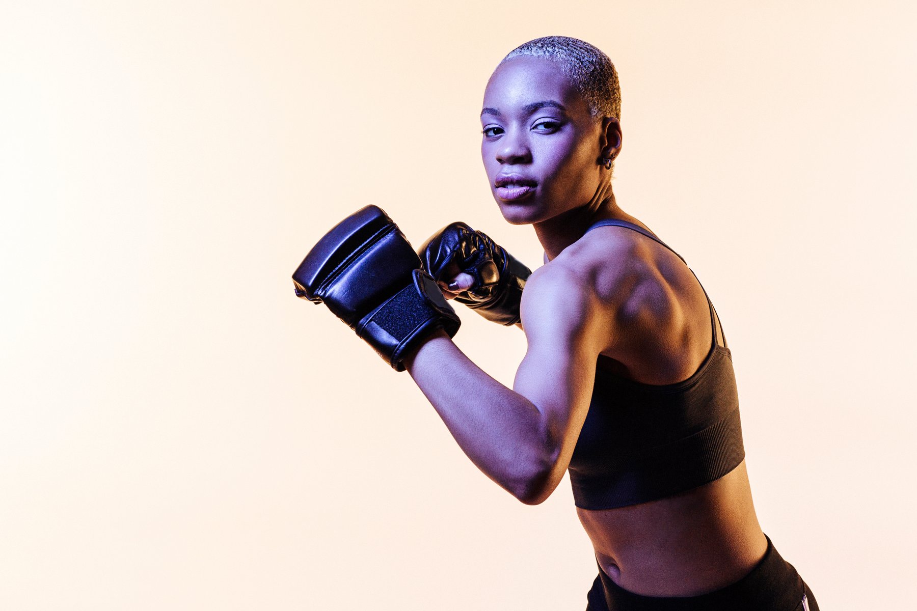 Boxer in gloves photographed against a plain studio background