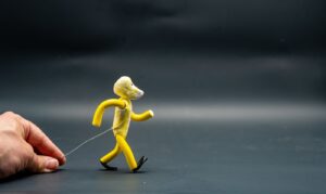 Hand adjusting a wire-supported clay character for stop motion animation