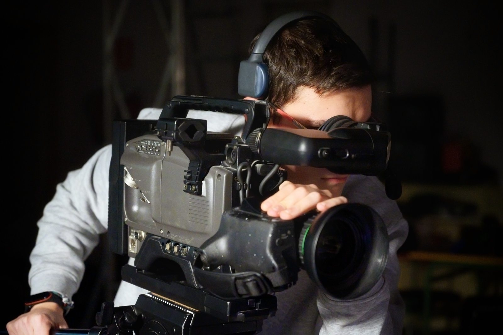 Camera operator composing a shot through a professional video camera
