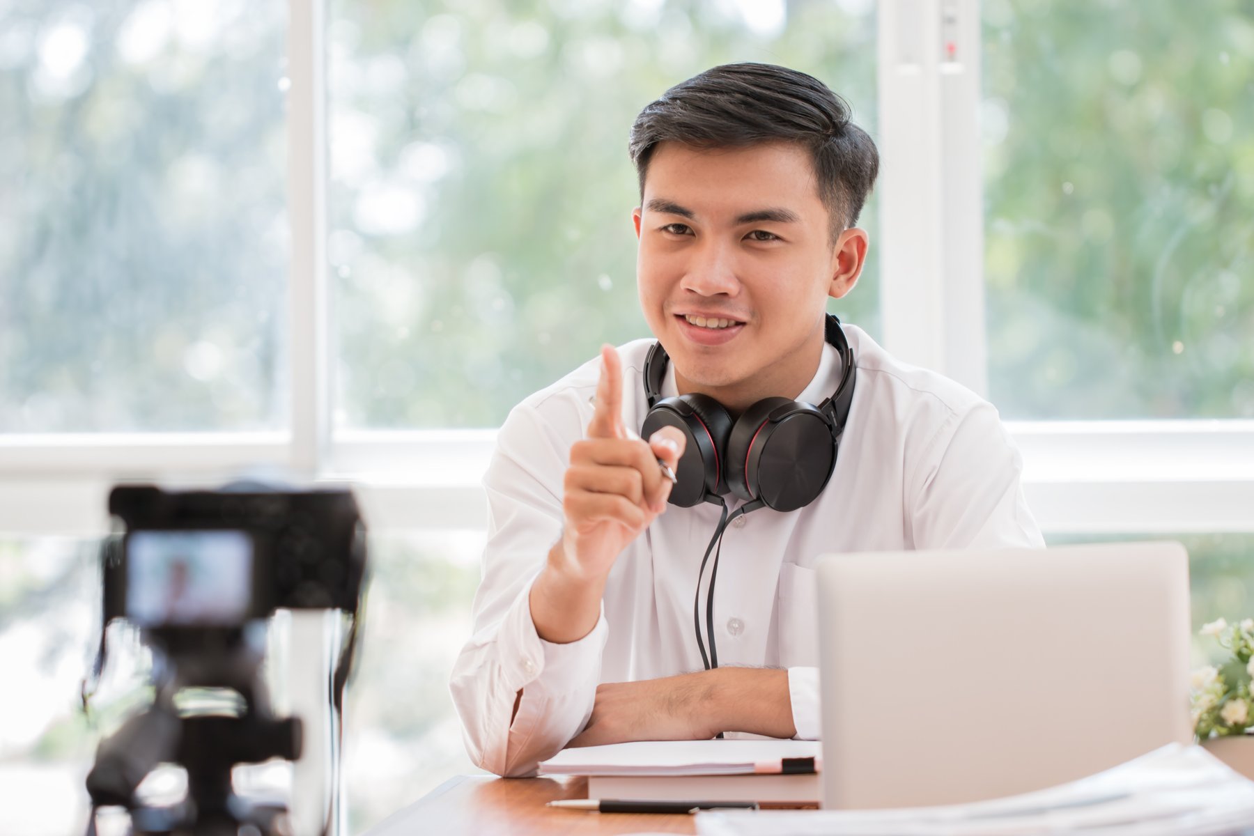 A presenter explaining a lesson to a camera beside a laptop