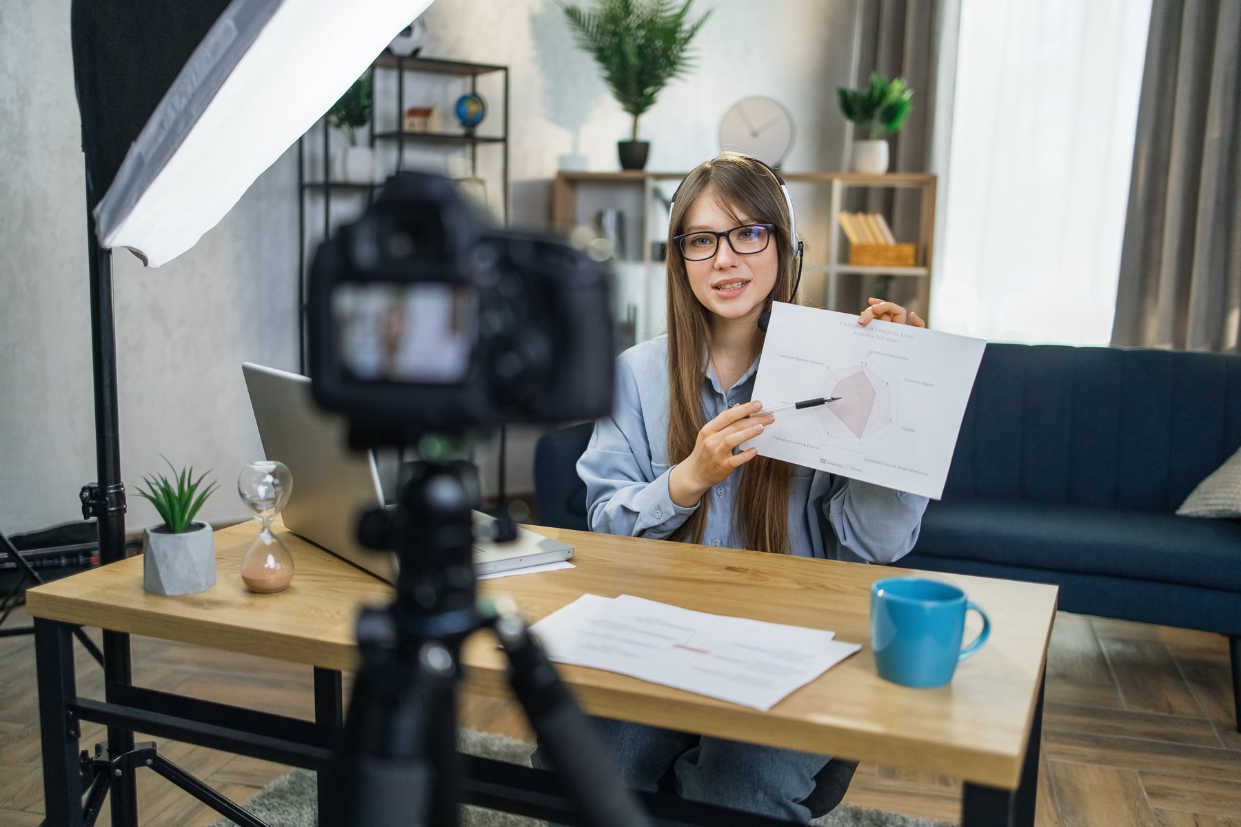A presenter recording a lesson with a chart and camera