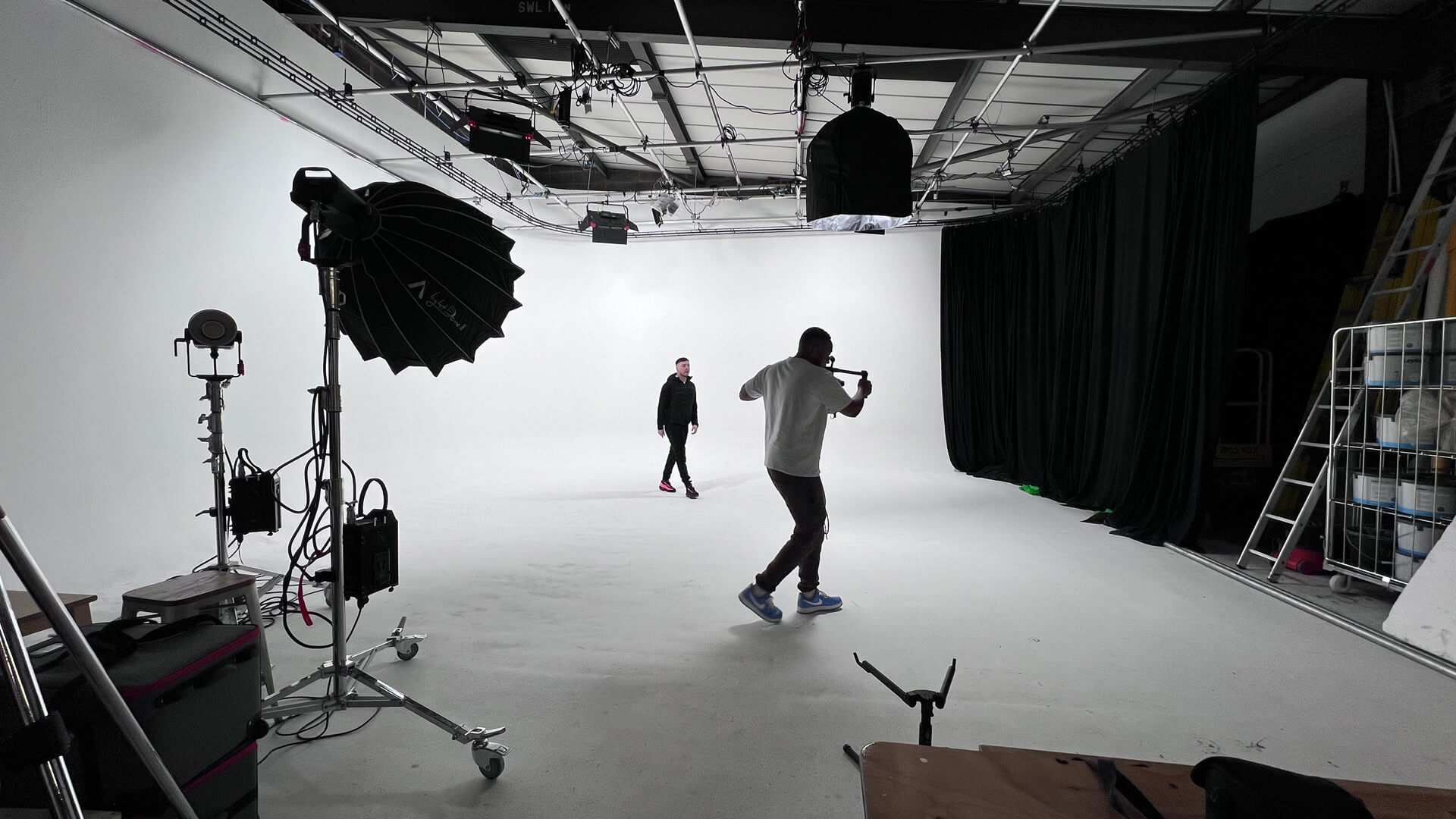 Camera operator filming a performer in the white infinity cove studio at Cineview Studios